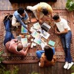 Kreativt team planerar ett projekt tillsammans på en matta